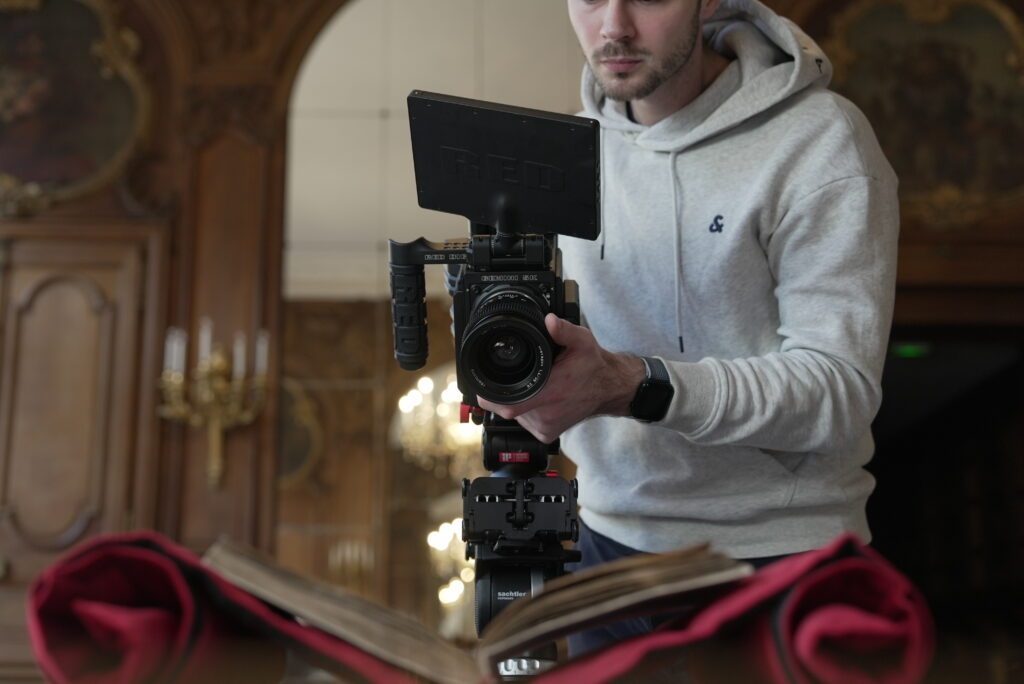 Cadreur filmant dans un intérieur au style architectural ancien pour un film historique sur Le Jikji de la BNF