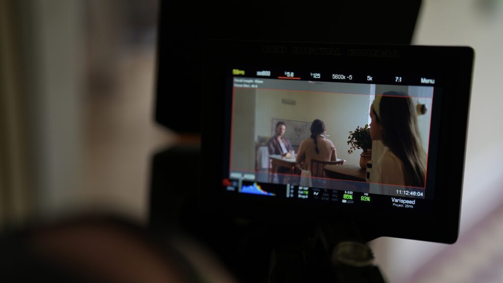 Moniteur de contrôle vidéo affichant le cadrage d'une interview lors d'un tournage de film corporate.