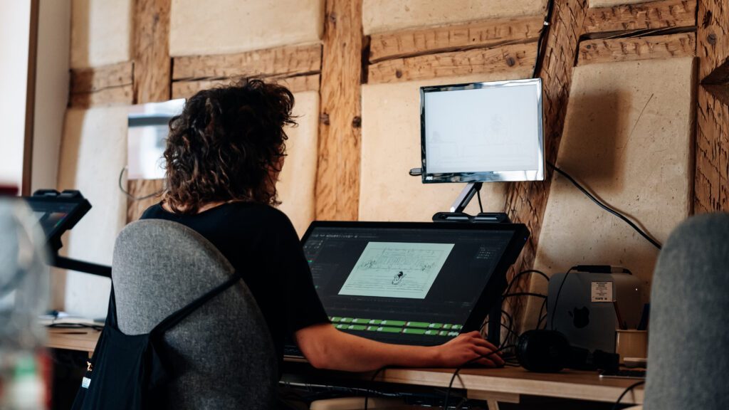 Graphiste travaillant sur une tablette graphique grand format dans le studio d'animation Amopix.