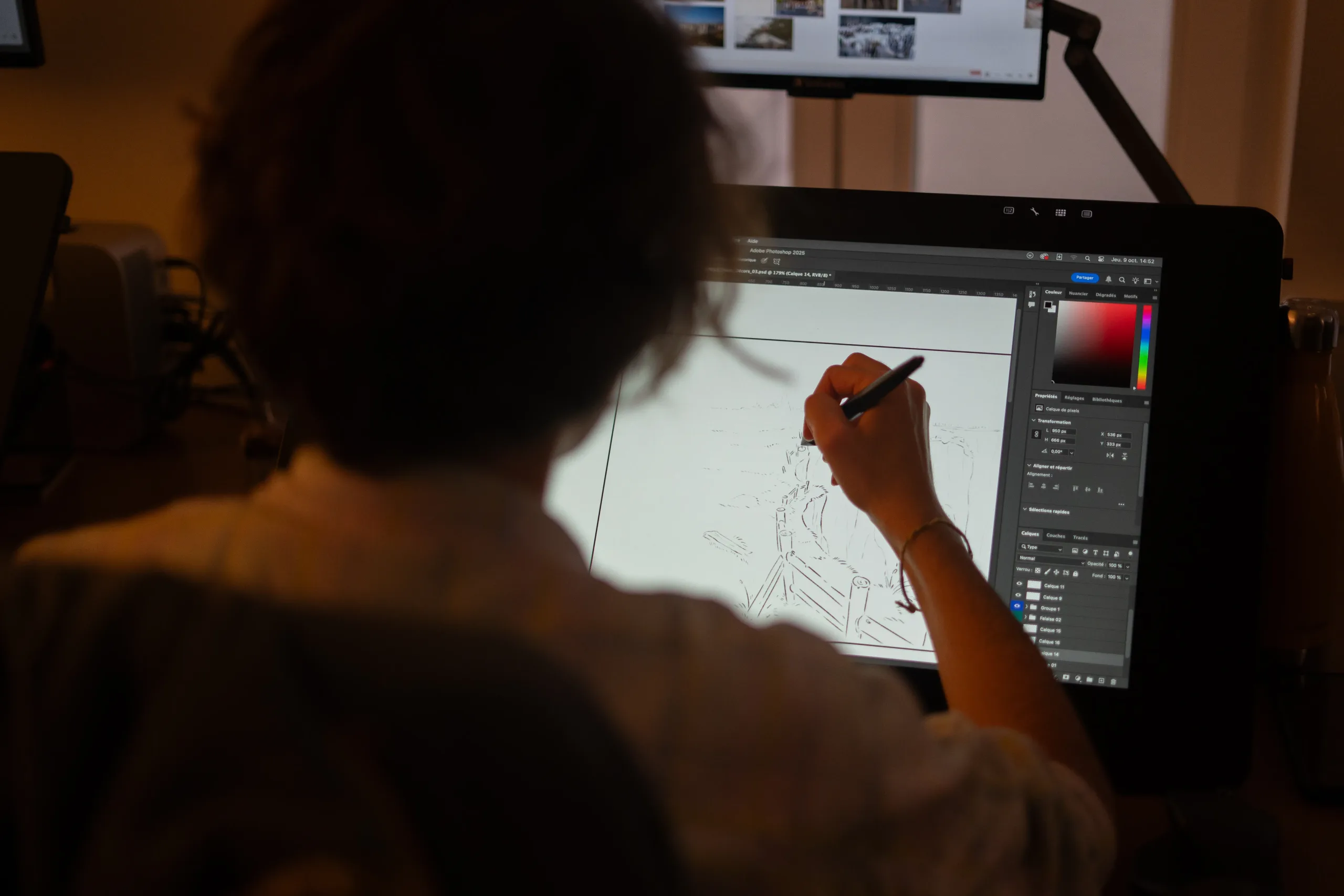 Silhouette de dos dessinant sur une tablette graphique face à un écran affichant un logiciel de dessin TV Paint