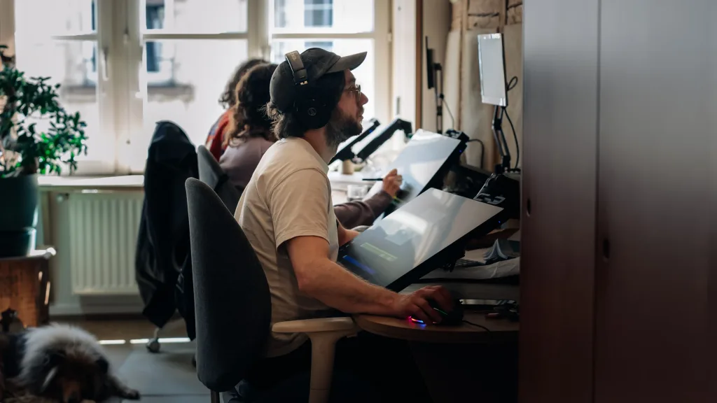 Animateur 2D concentré dessinant sur un écran interactif dans les locaux d'Amopix à Strasbourg.