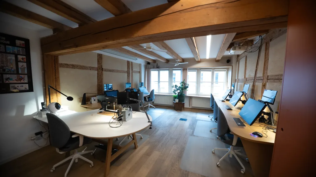 Open space chaleureux pour les animateurs dans les locaux d'Amopix avec stations de travail