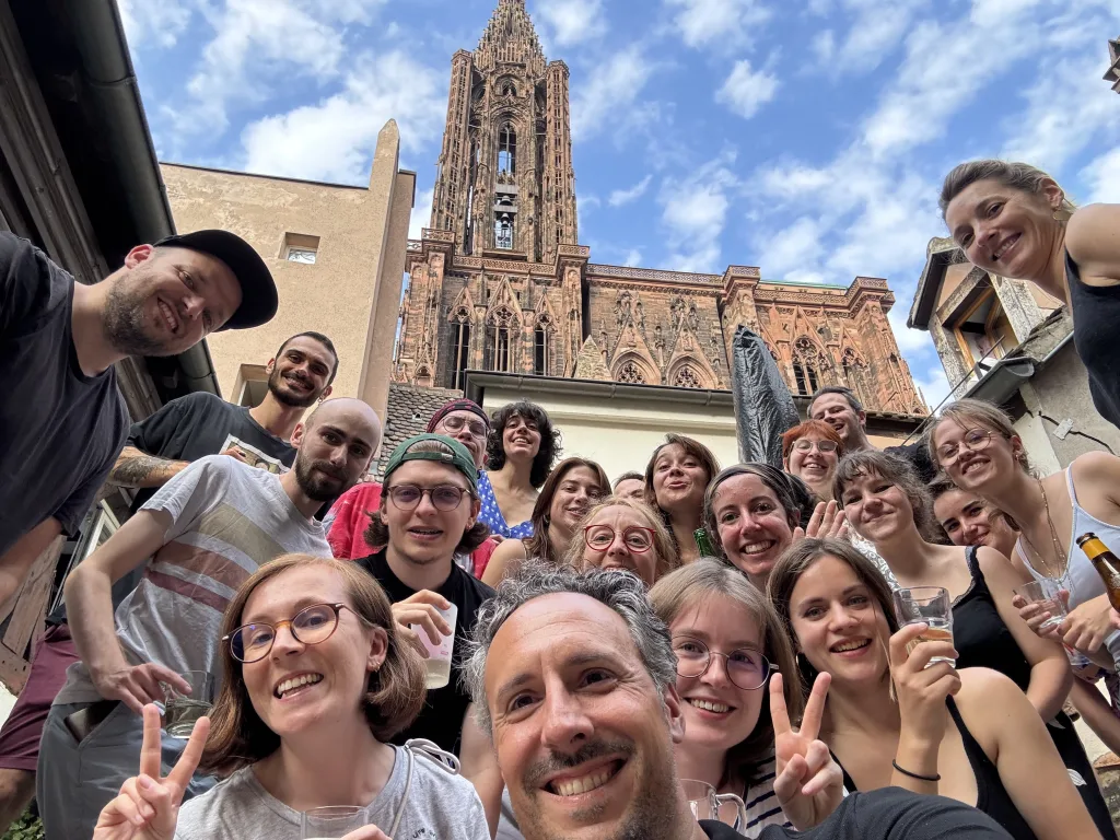 Équipe Amopix réunie sur la terrasse des locaux du studio à Strasbourg avec vue sur la cathédrale